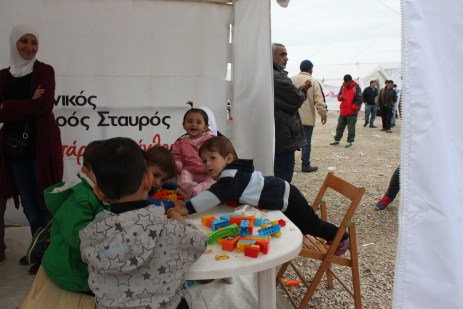 Children draw at an activity tent. That's Missam smiling